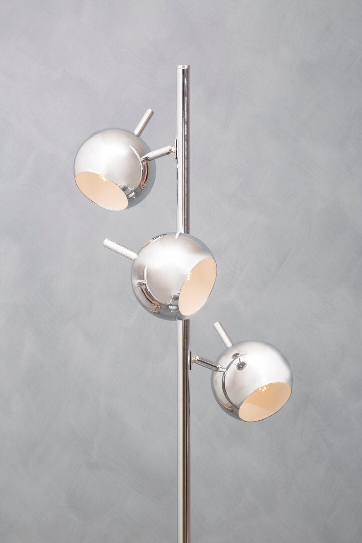Modern floor lamp with three spherical lights on a gray background