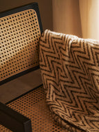 Close-up of a chair with wicker backrest and patterned cushion
