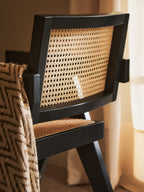 Chair with black frame and woven backrest in a room setting