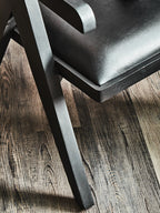 Black chair with wooden legs on a wooden floor