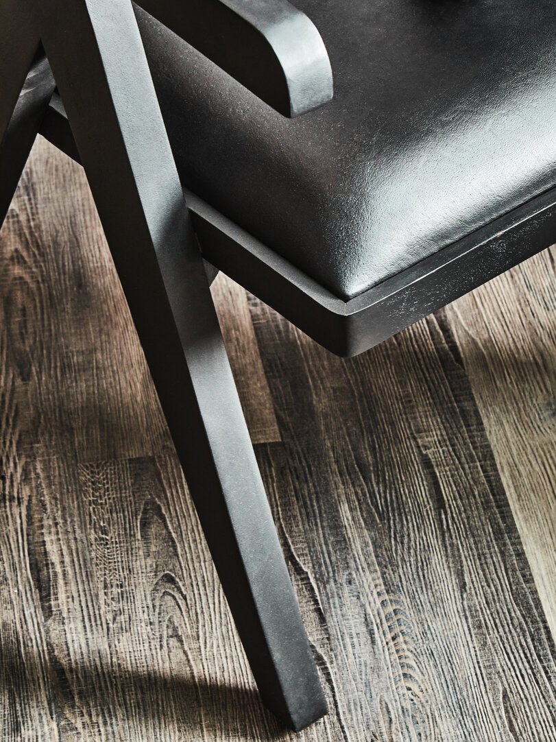 Black chair with wooden legs on a wooden floor