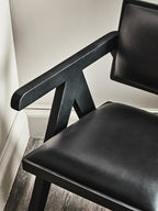 Black leather chair with armrests in a corner