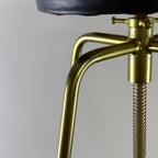 Close-up of a brass clamp with a black object on a gray background