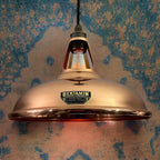 Copper pendant light with 'Benjamin' label against a textured wall.