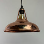 Copper pendant light with a visible brand label on a plain background