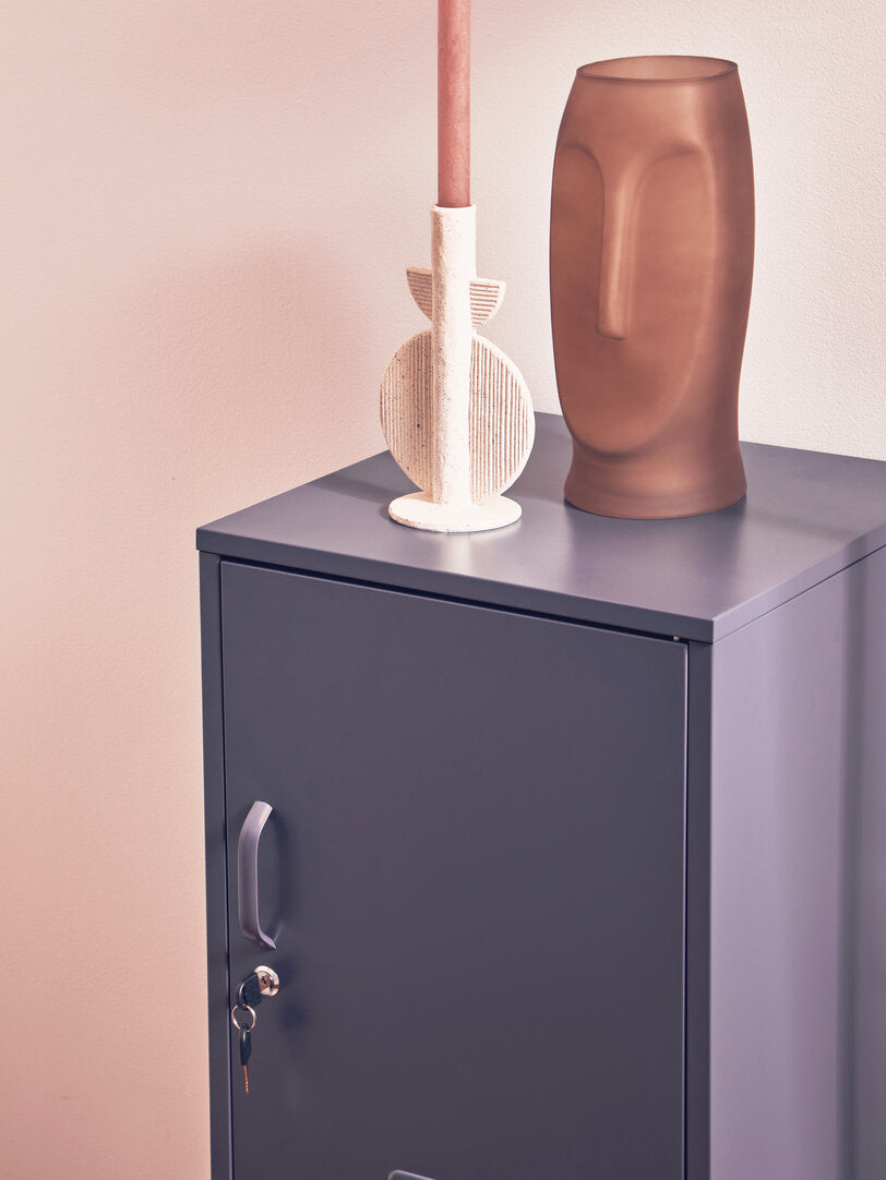 Vases on a metallic cabinet against a pink wall