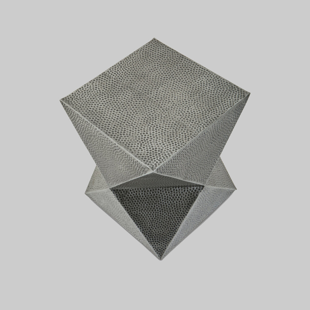 Geometric metal stool side table on a light gray background
