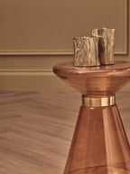 orange glass side table with two decorative candles on a neutral background