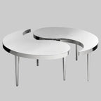 Two modern, round tables with chrome legs on a gray background