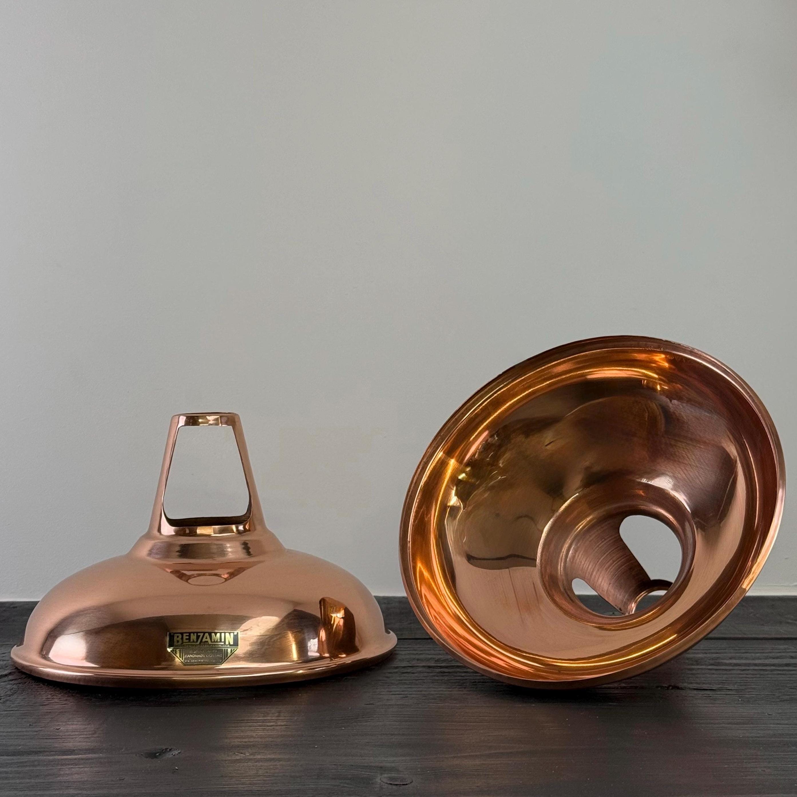 Two copper metal bowls on a wooden surface with a gray background