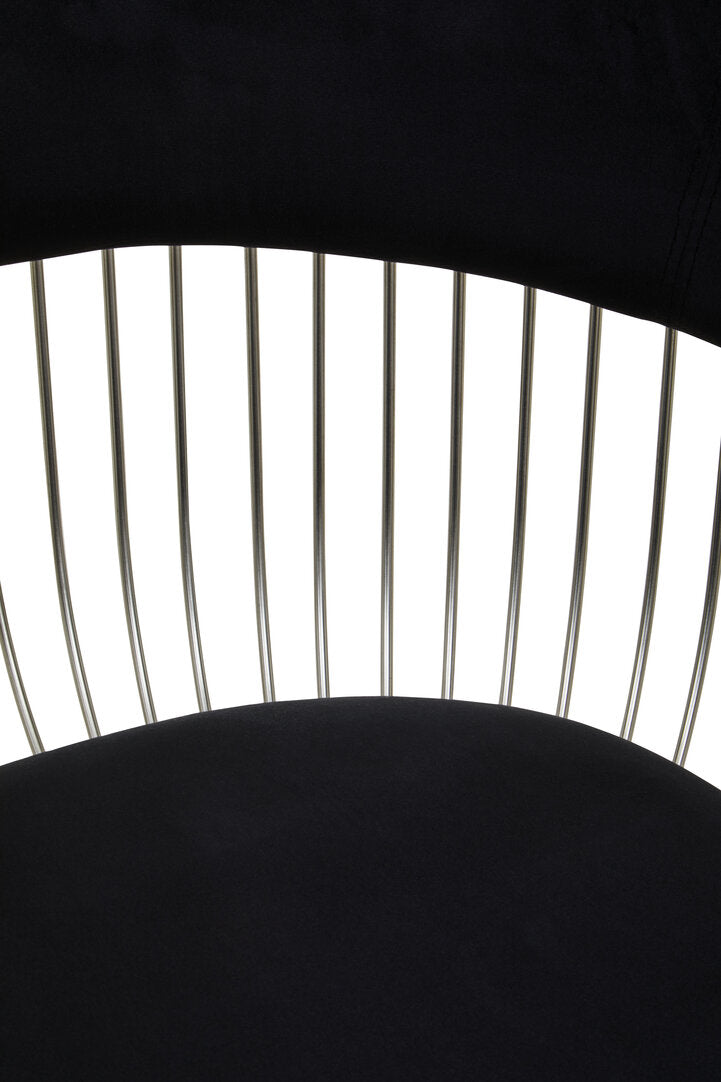 Close-up of a black metal chair with a curved backrest