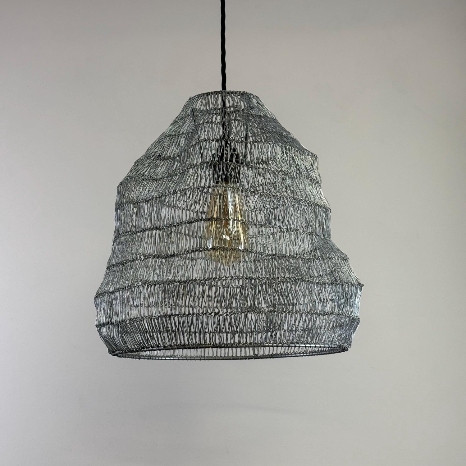 Woven metal pendant light with a neutral background