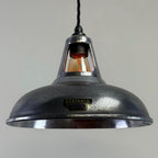 Industrial-style pendant light with a visible brand name on a grey background