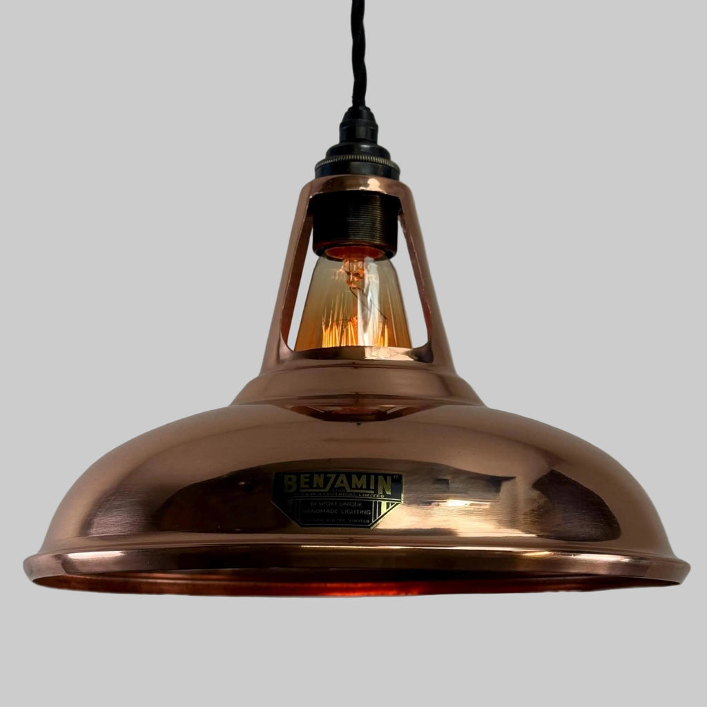 Copper pendant light with a visible brand label on a gray background